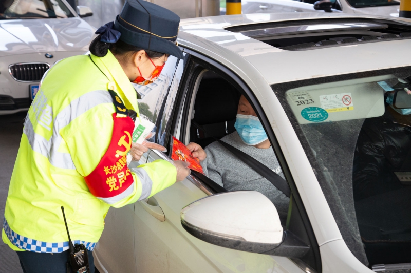 長(cháng)沙收費站志愿者向乘客贈送中國紅口罩  （周全攝）